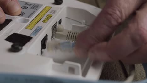 network engineer fixing ethernet cables between devices