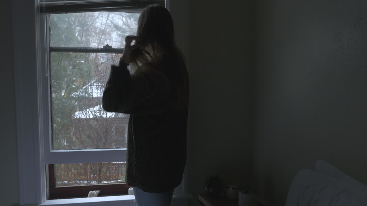 A woman looking out of her bedroom window.