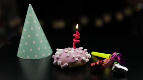 Party.-Pink-donut-and-a-red-festive-candle-on-it.-Golden-confetti-fall