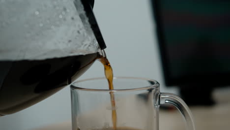 pouring coffee from a pot into a glass