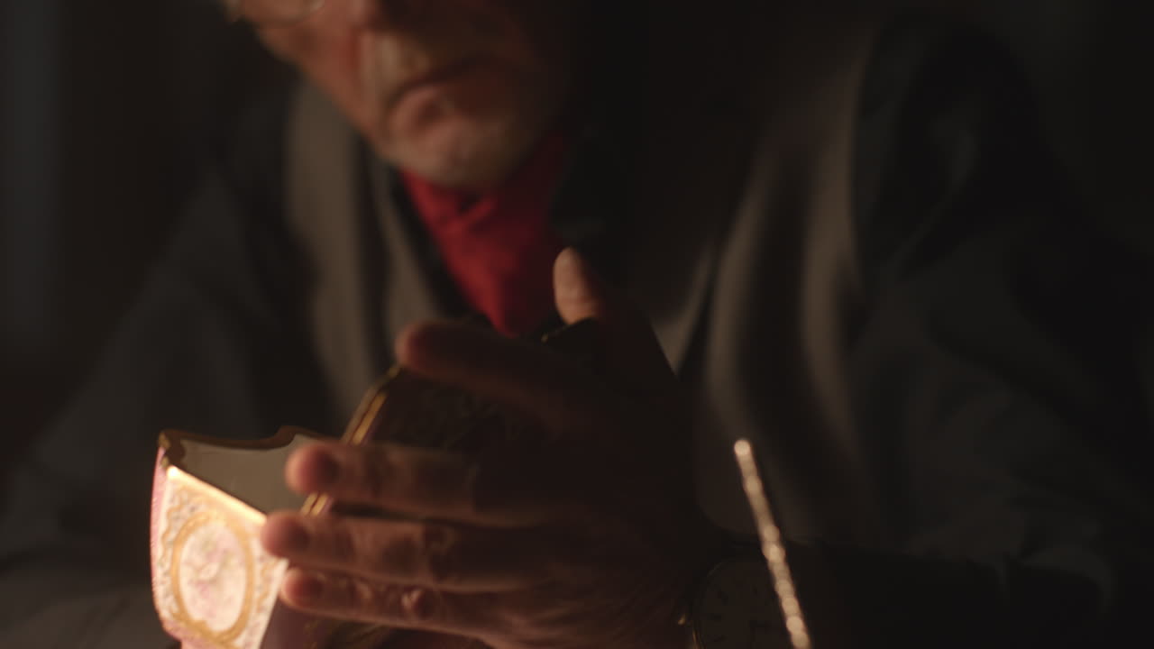 Older passionate man evaluates an old porcelain box