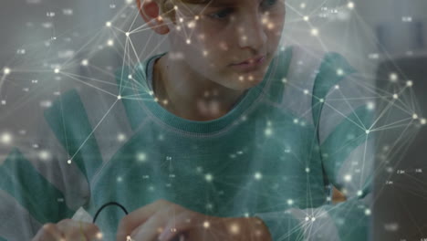 animación de una red de círculos conectados sobre un niño caucásico enfocado usando una computadora portátil