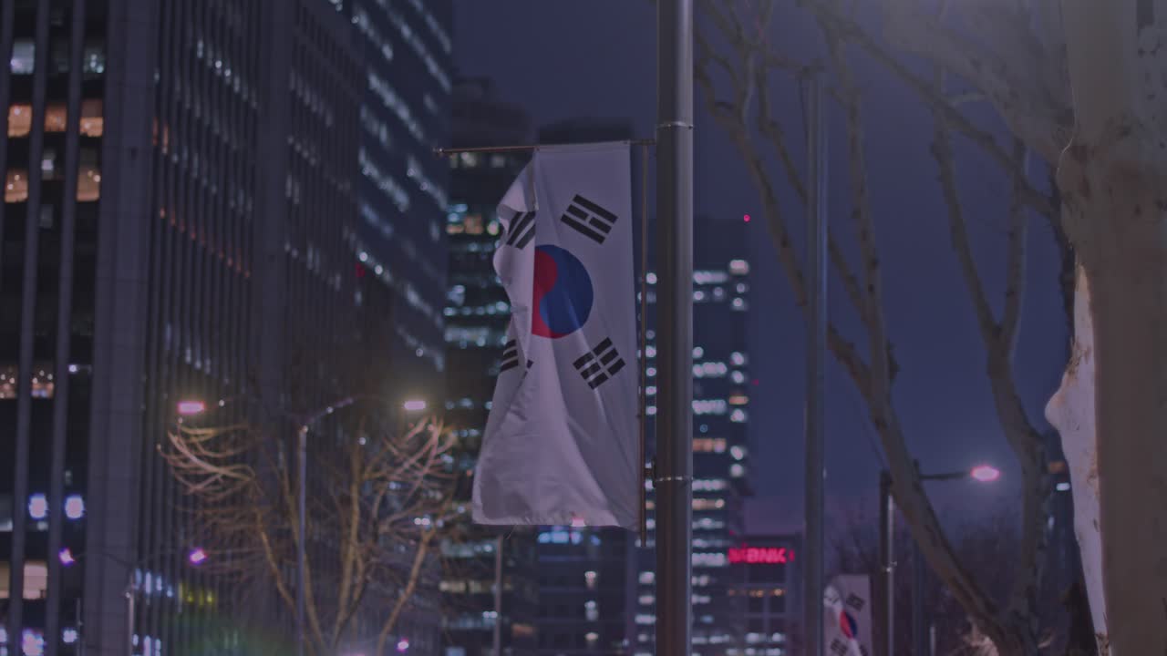 건물과 건축물이 있는 서울 도심에서 밤에 펄럭이는 한국 국기
