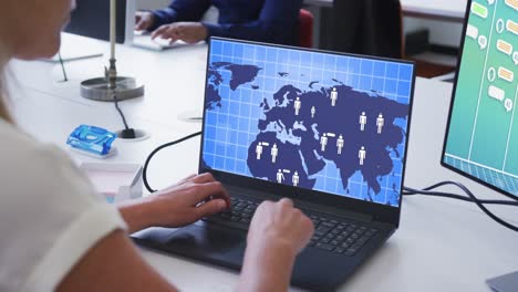 mujer de negocios caucásica usando computadoras con procesamiento de datos en la pantalla en la oficina