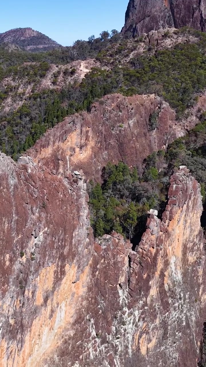 Drone riprende pareti di roccia vulcanica e foreste di eucalipto nel Parco Nazionale Warrumbungle, Australia