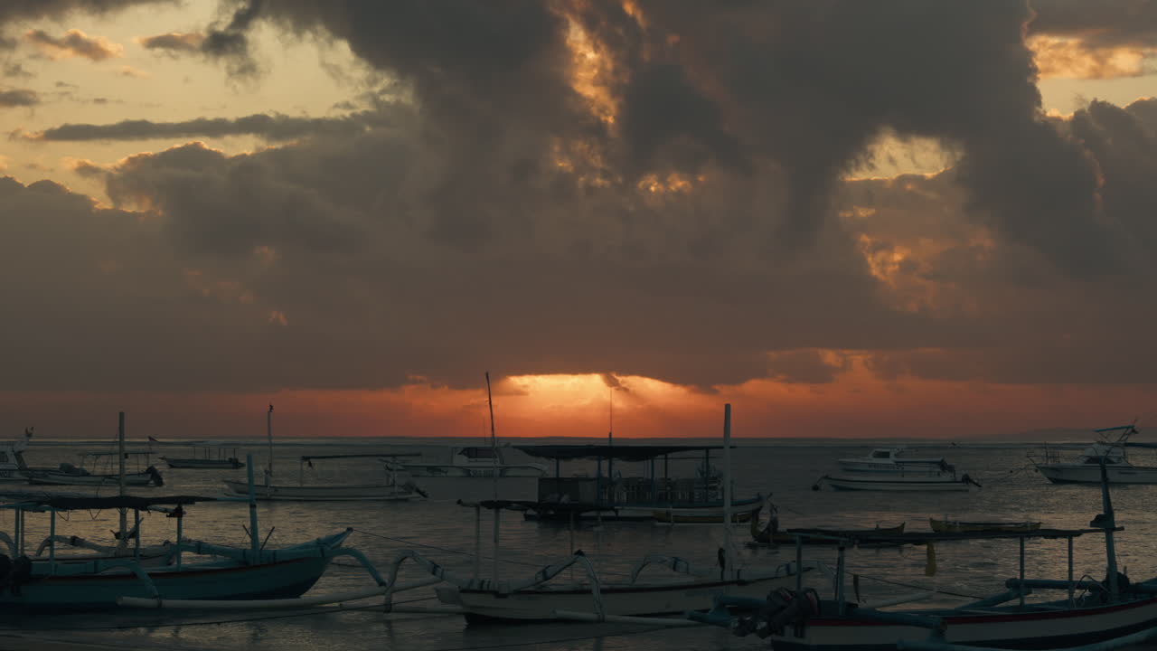 해변에서 보트 해양 바다와 해가 뜨는 구름을 통해  ⁇ 빛 발리 항구에서 황금 하늘