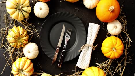 black plate surrounded by yellow pumpkins