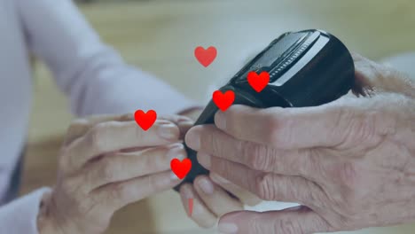 animación de corazones caídos sobre personas que utilizan terminales de pago
