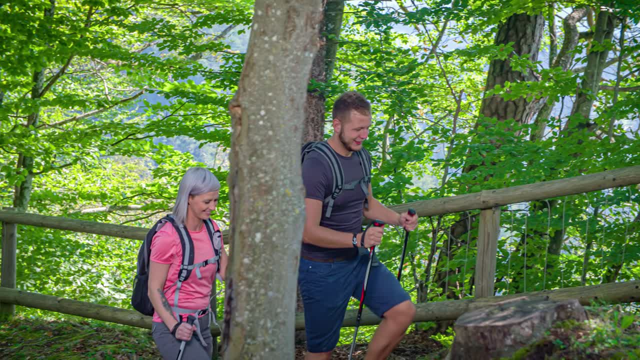 Boy and girl walking up a mountain path in slow-motion. Green window, Slovenia