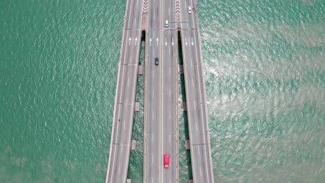 Aerial-surface-view-of-Penang-Bridge-Malaysia-traffic-lanes-with-bidirectional-traffic,-drone-bird's-eye-view-tilt-up-shot