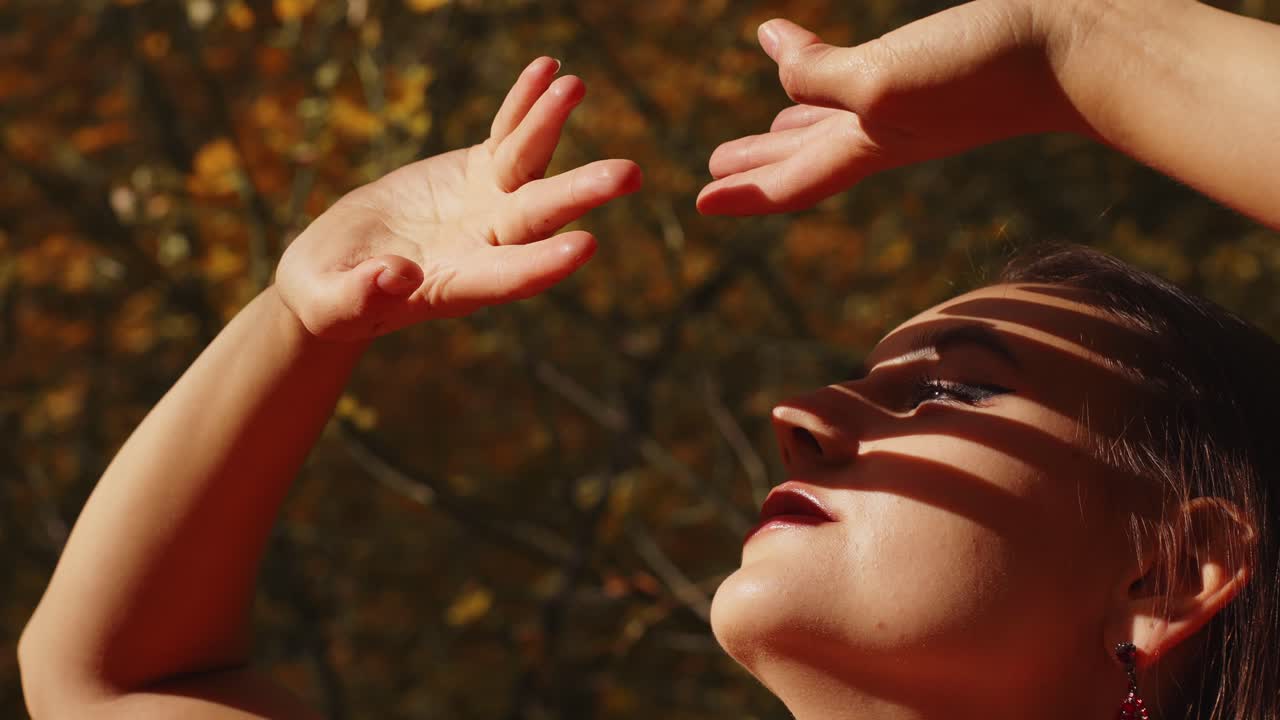 A Captivating Moment of Joy and Elegance: A Woman Posing Gracefully with Outstretched Arms Against a Vibrant Autumn Backdrop, Radiating Confidence and Serenity