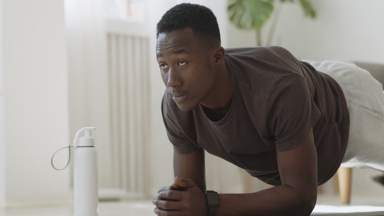 hombre haciendo un ejercicio de tabla en casa