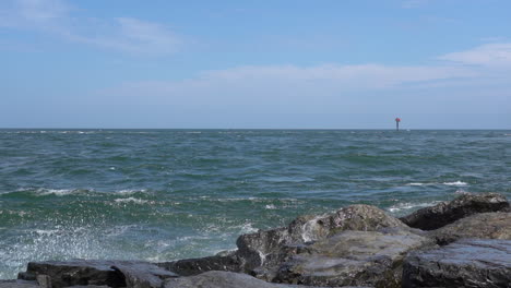 the waves from the ocean breaking over the rocks on the shore