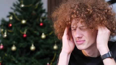 young man experiencing headache during christmas holiday