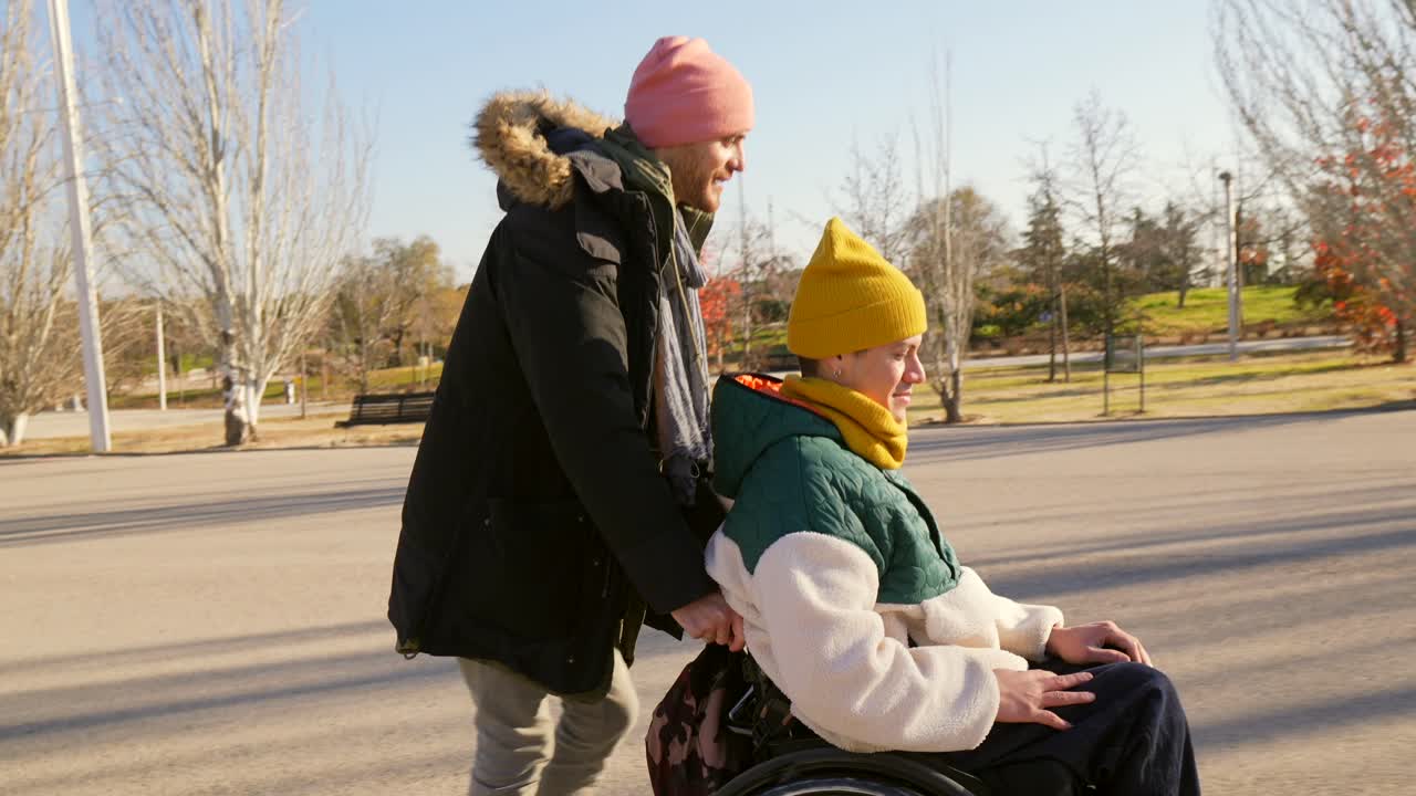Man Pushing Woman in Wheelchair Through Autumn Park