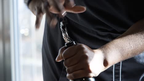 Close-up-of-male-hands-uncorking-a-wine-bottle-with-sunlight-coming-through-the-window-in-the-background-on-a-sunny-day