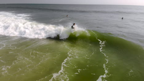 Epische-Drohnenfahrt-Eines-Surfers,-Der-Auf-Einer-Welle-Reitet