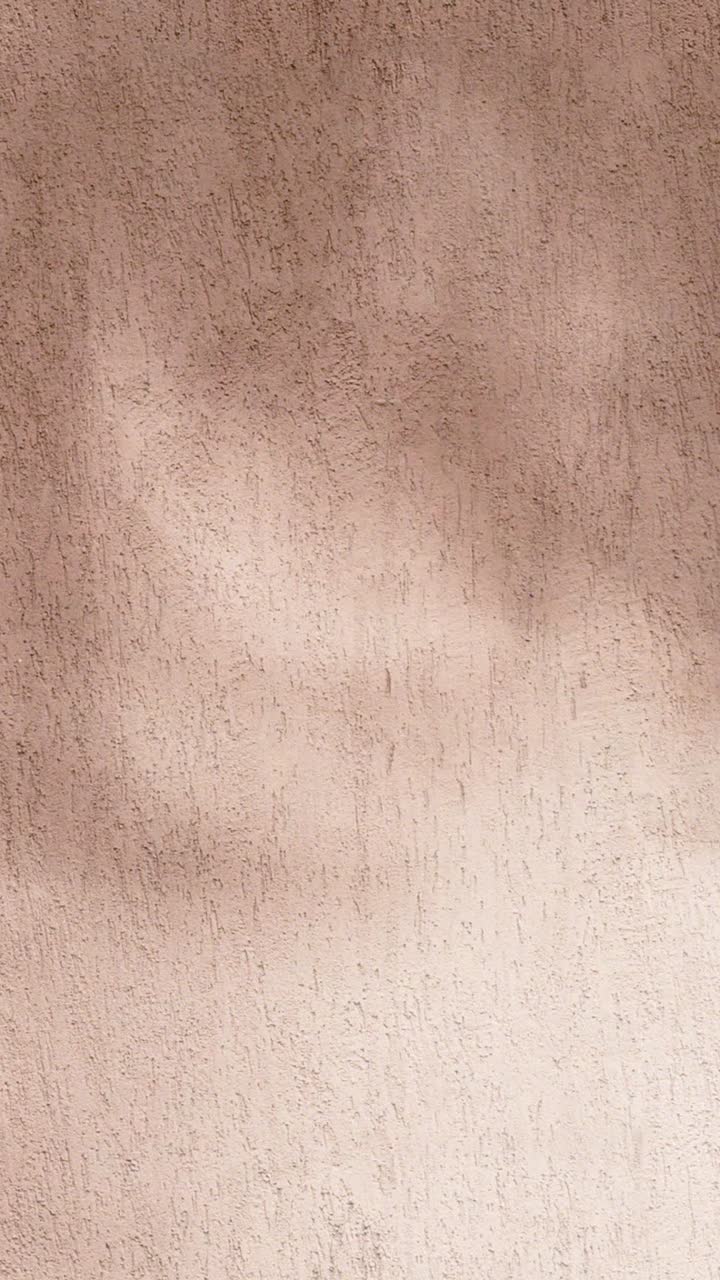Ombre in movimento su una parete beige texturizzata