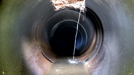 underground round concrete sewer tunnel. urban sewage flowing throw sewer pipe