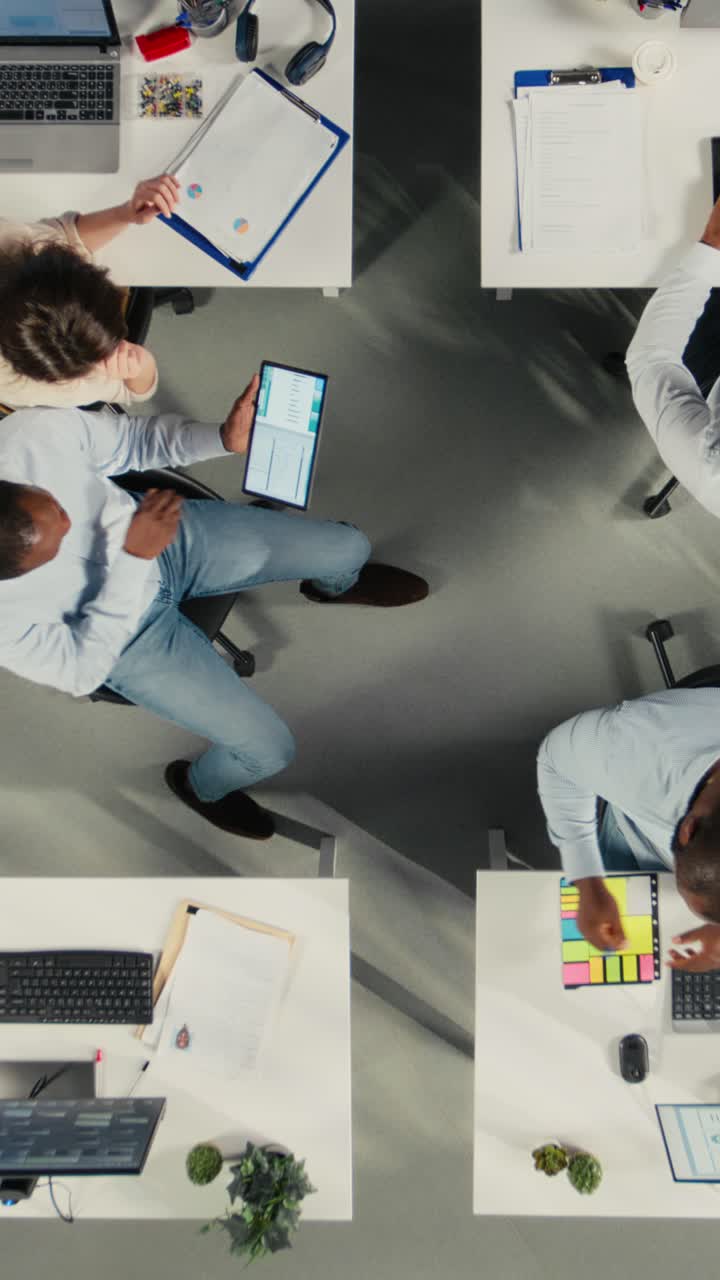 Vertical Video Top down view zoom in of corporate workers assessing business objectives