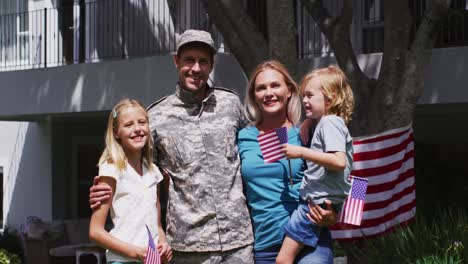 Porträt-Eines-Kaukasischen-Militärmannes-In-Uniform-Und-Seiner-Familie,-Die-Im-Garten-Lächelt