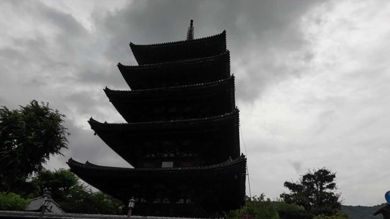 Ampia inquadratura di una tradizionale pagoda a cinque piani sotto cieli nuvolosi a Kyoto, Giappone.