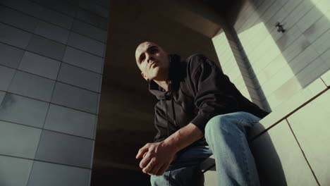 man in hoodie sitting outdoors