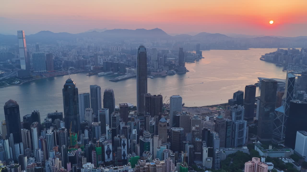 Cinematic Aerial view of Hong Kong skyline at golden hour featuring IFC and ICC towers, symbolizing global finance, modern architecture, and a vibrant hub for travel and business