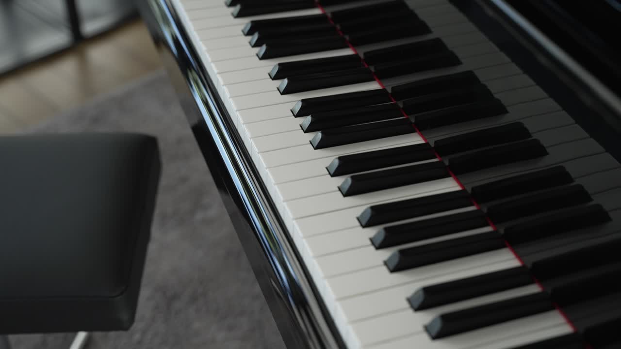 cerca de teclas de piano blancas y negras pulidas con un banco de cuero cerca