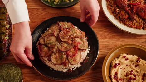 hand serving a plate of middle eastern food
