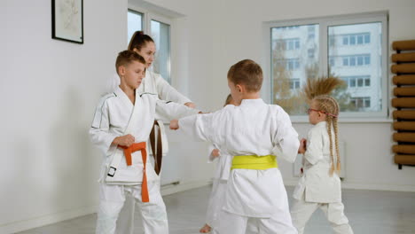 niños en kimono blanco en la clase de artes marciales