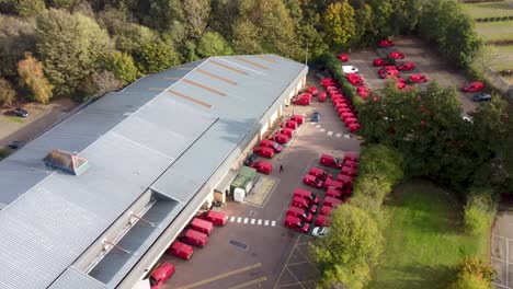 flying over royal mail sorting office in canterbury with red delivery vans - dolly forward