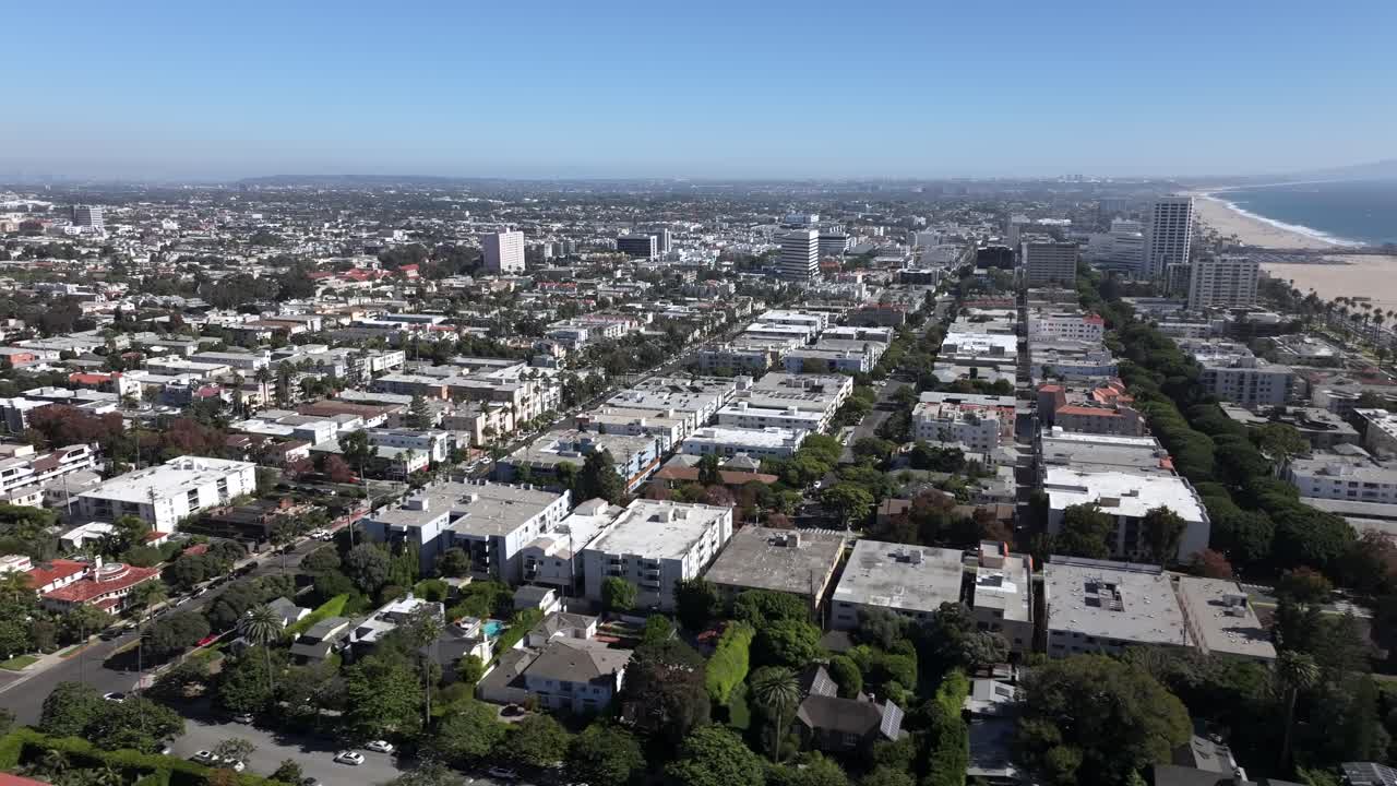 Drone Shot of Santa Monica landscape, California USA, Buildings and Streets Behind Beach and Pier on Sunny Day