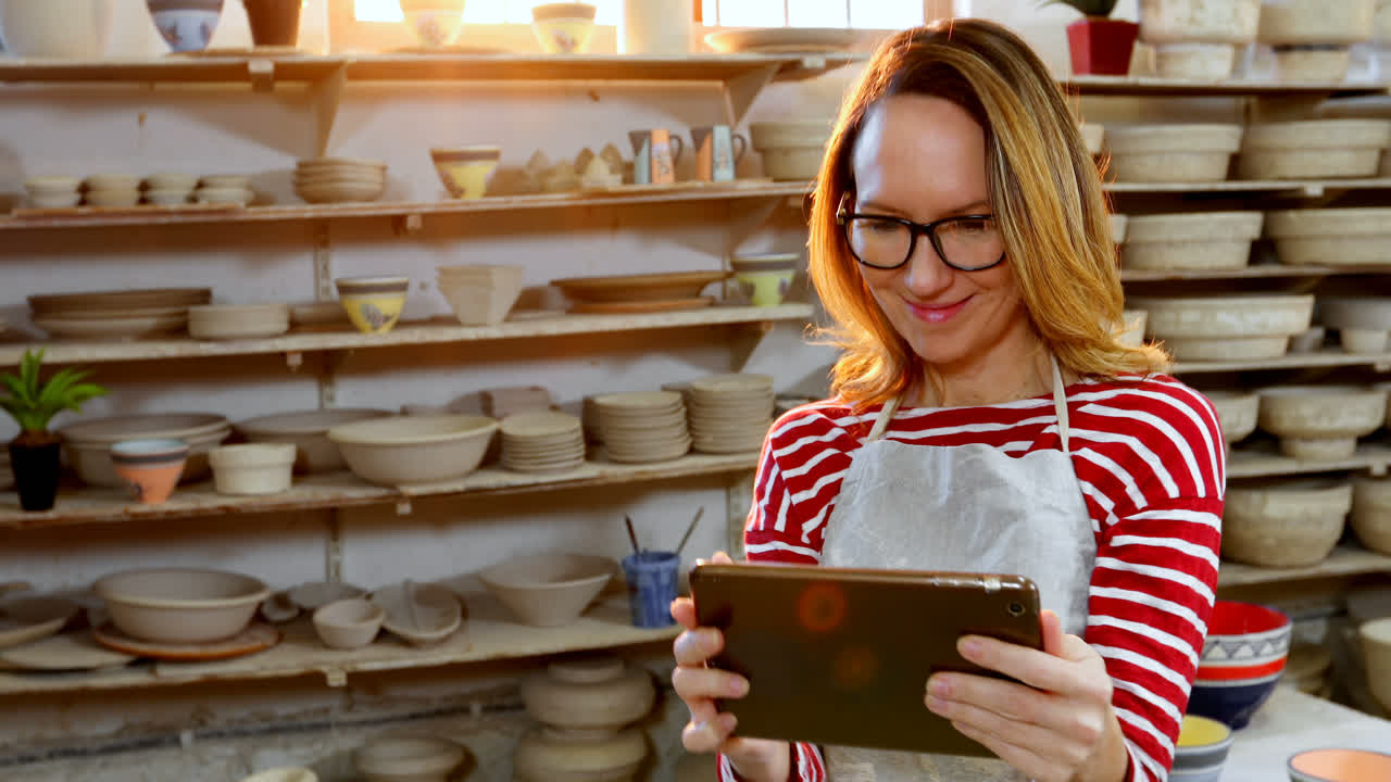 una alfarera usando una tableta digital 4k