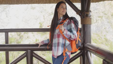 young backpacker standing on a mountain lookout