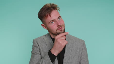 Cheerful-business-man-in-jacket-looking-at-camera-doing-phone-gesture-like-says-hey-you-call-me-back