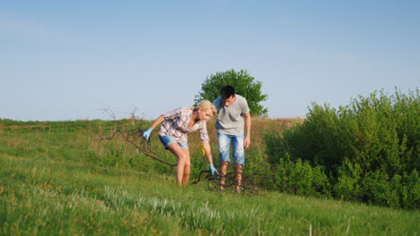 A-Woman-With-Her-Teenage-Son-Is-Cleaning-Up-The-Garbage-In-The-Meadow-1