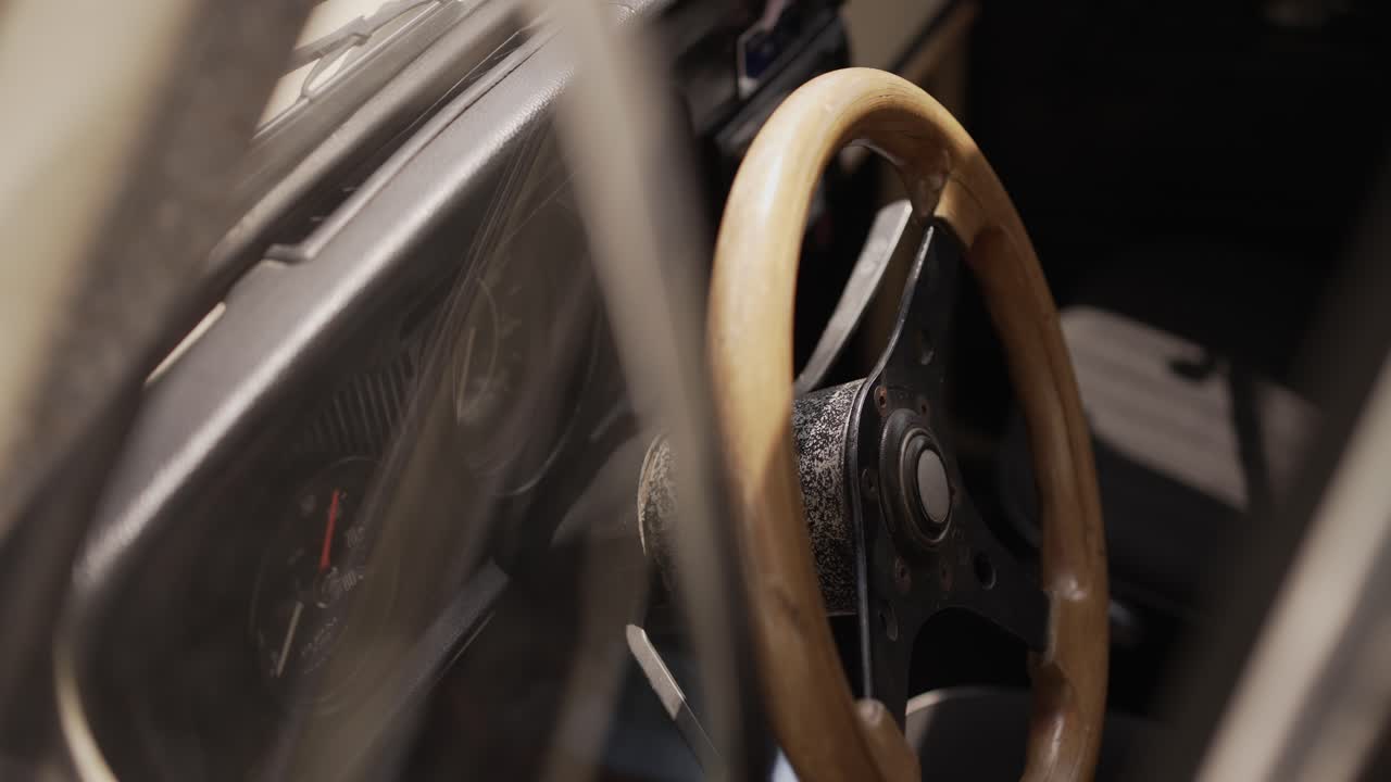 Close up of a vintage Volkswagen Beetle's interior, focusing on the wooden steering wheel