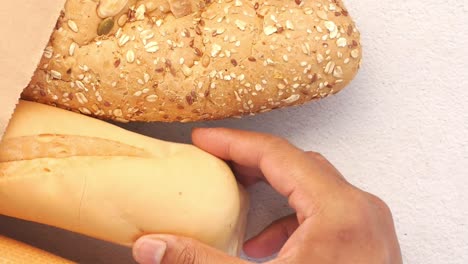 hand picking bread from paper bag