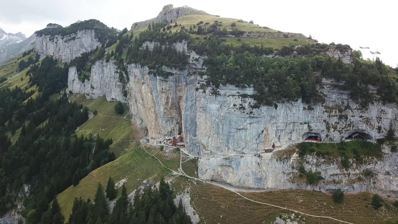 Wonderful aerial view of the Ebenalp mountain with the Wildkirchli caves and the Aescher cliff restaurant nestled into the rock face Alpstein, Switzerland