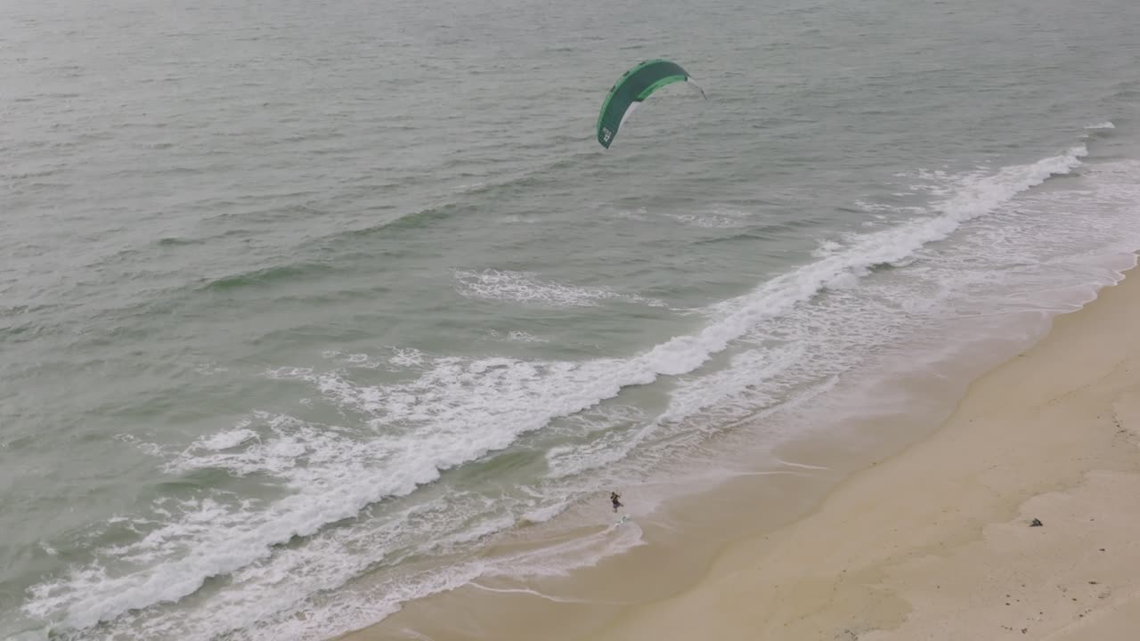 surfista de viento subiendo a la playa y saltando de la tabla en una playa en sierra leona áfrica