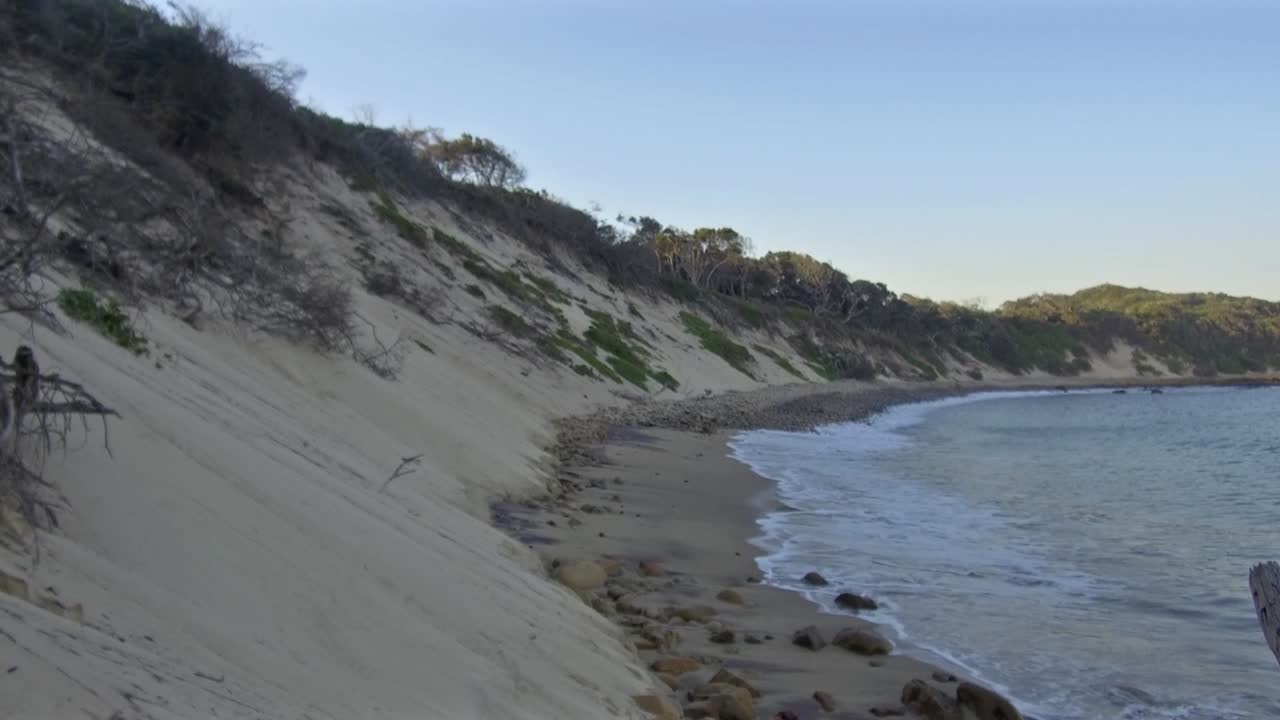 las olas llegan a la orilla entre la playa de glen gariff y las cuatro estaciones.