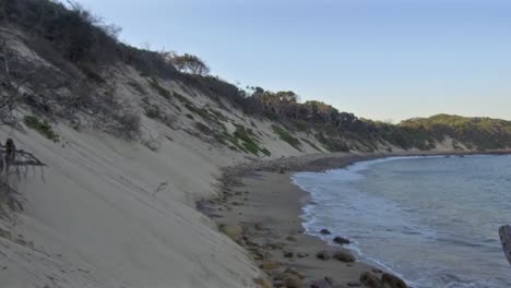 las olas llegan a la orilla entre la playa de glen gariff y las cuatro estaciones.