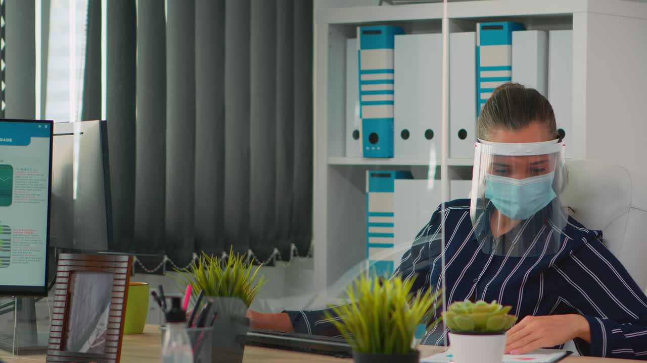 деловая женщина, носящая защиту лица на новом нормальном рабочем месте