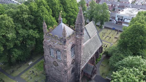 Aerial-view-above-rural-English-town-countryside-idyllic-church-bell-tower-and-graveyard