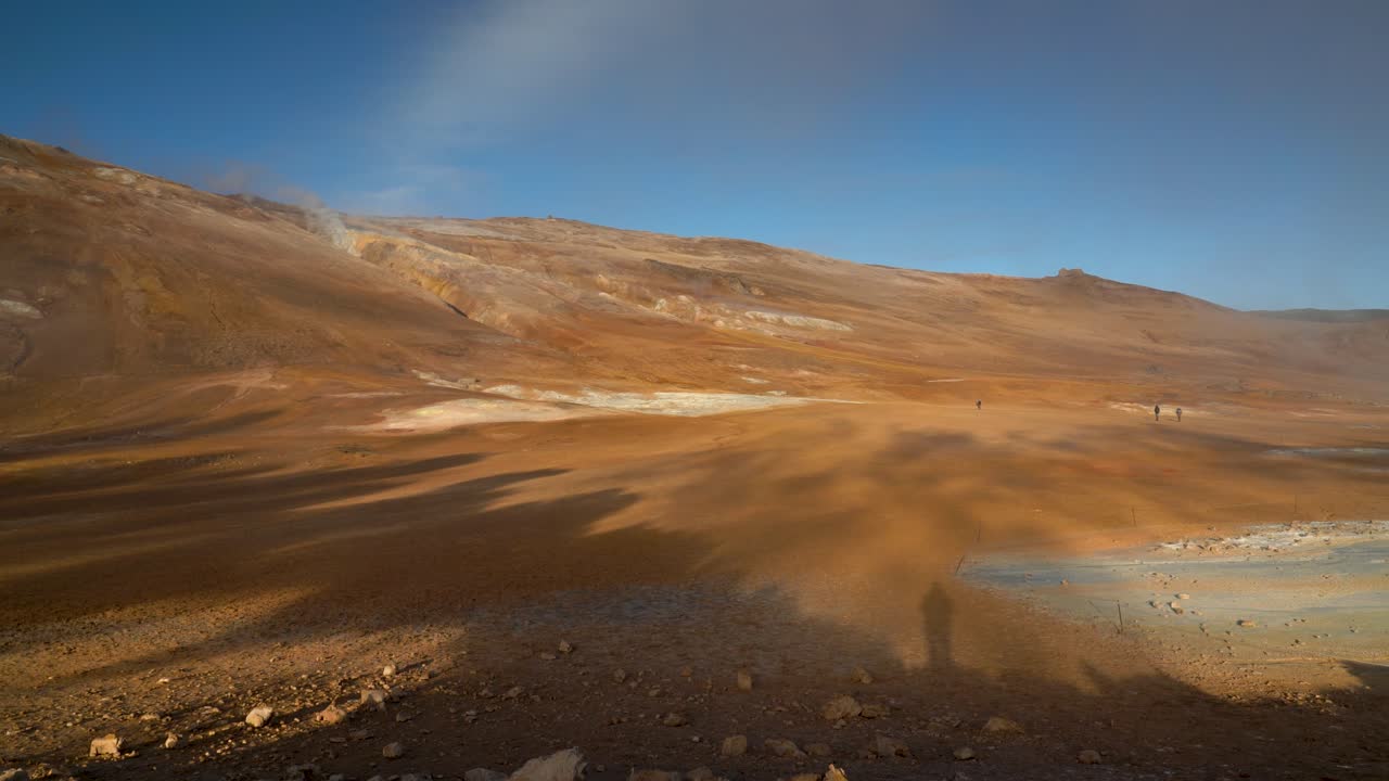 Shadows of Geothermal Steam Rising Alongside the Silhouettes of People Standing - Static Shot