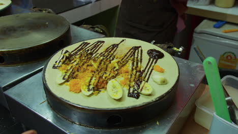 Vendedor-De-Comida-Callejera-Vendiendo-Crepe-Con-Nutella-De-Plátano-En-Un-Bazar-Nocturno,-Hat-Yai,-Tailandia