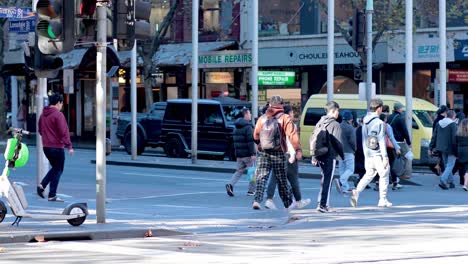 people and cyclists crossing a busy intersection