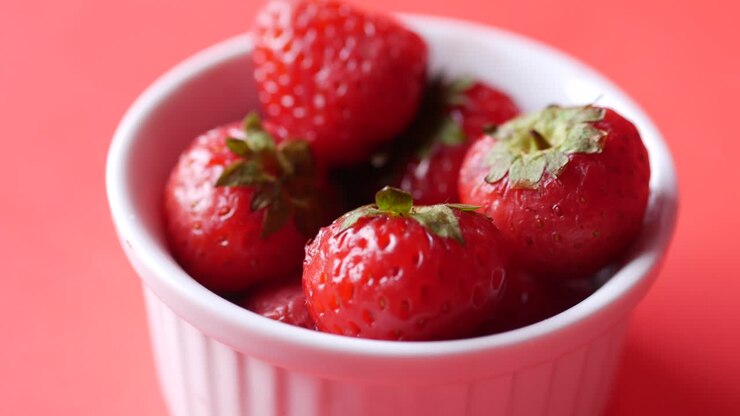Ripe red strawberries in a bowl on table