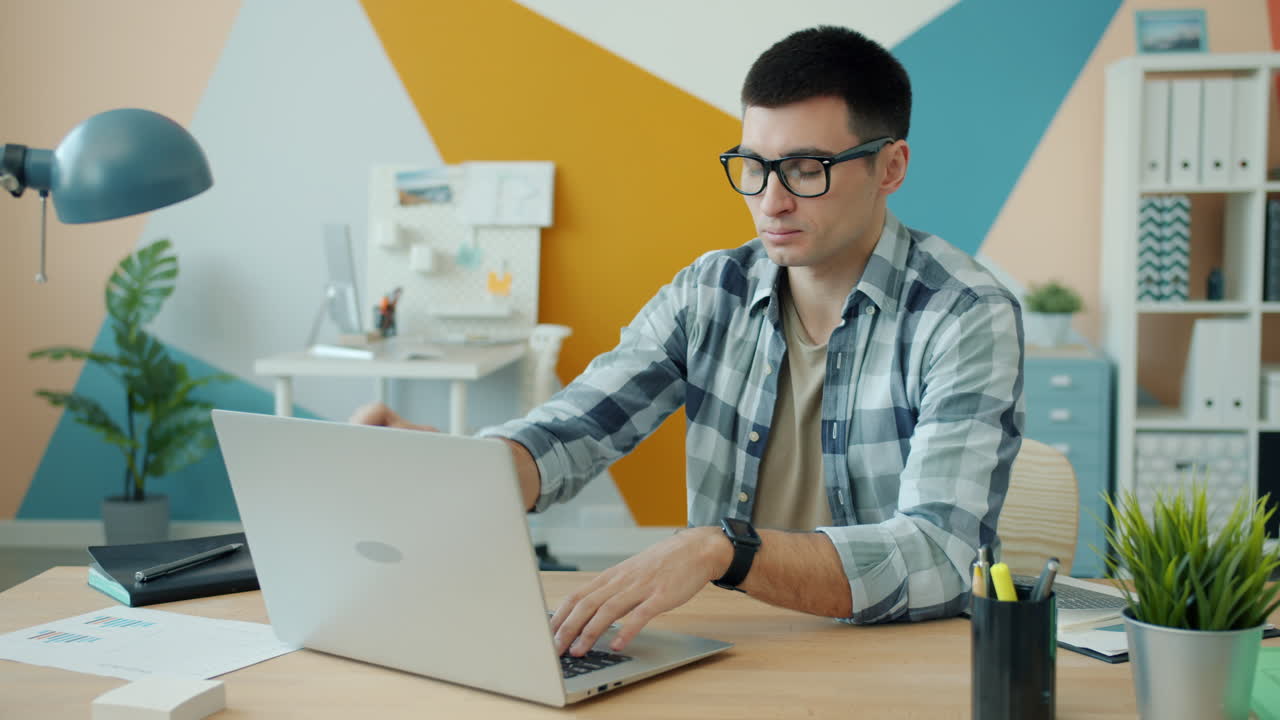 hombre trabajando en una computadora portátil en una oficina moderna